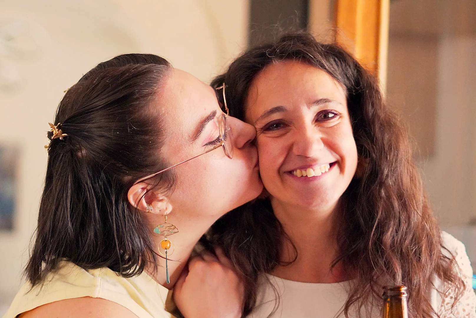 Deux femmes échangent un bisou sur la joue à la crémaillère de Leslie.