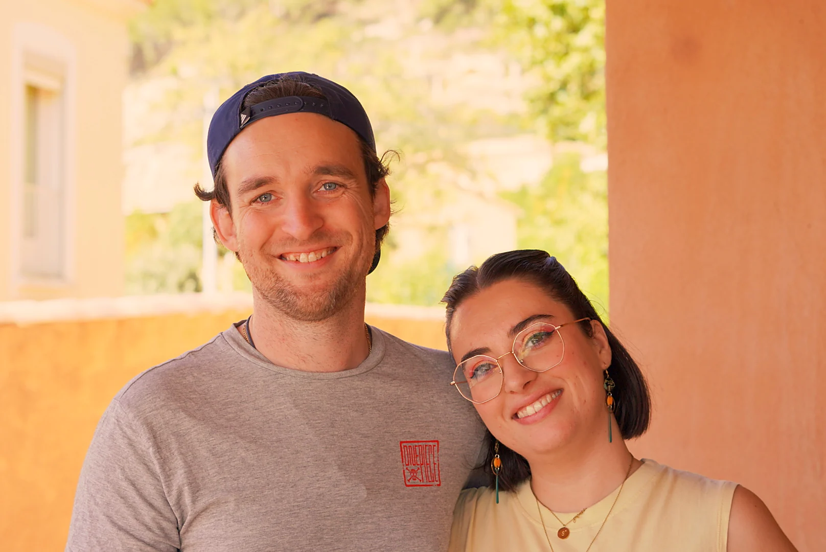 Un couple sourit ensemble pendant la crémaillère de Leslie.