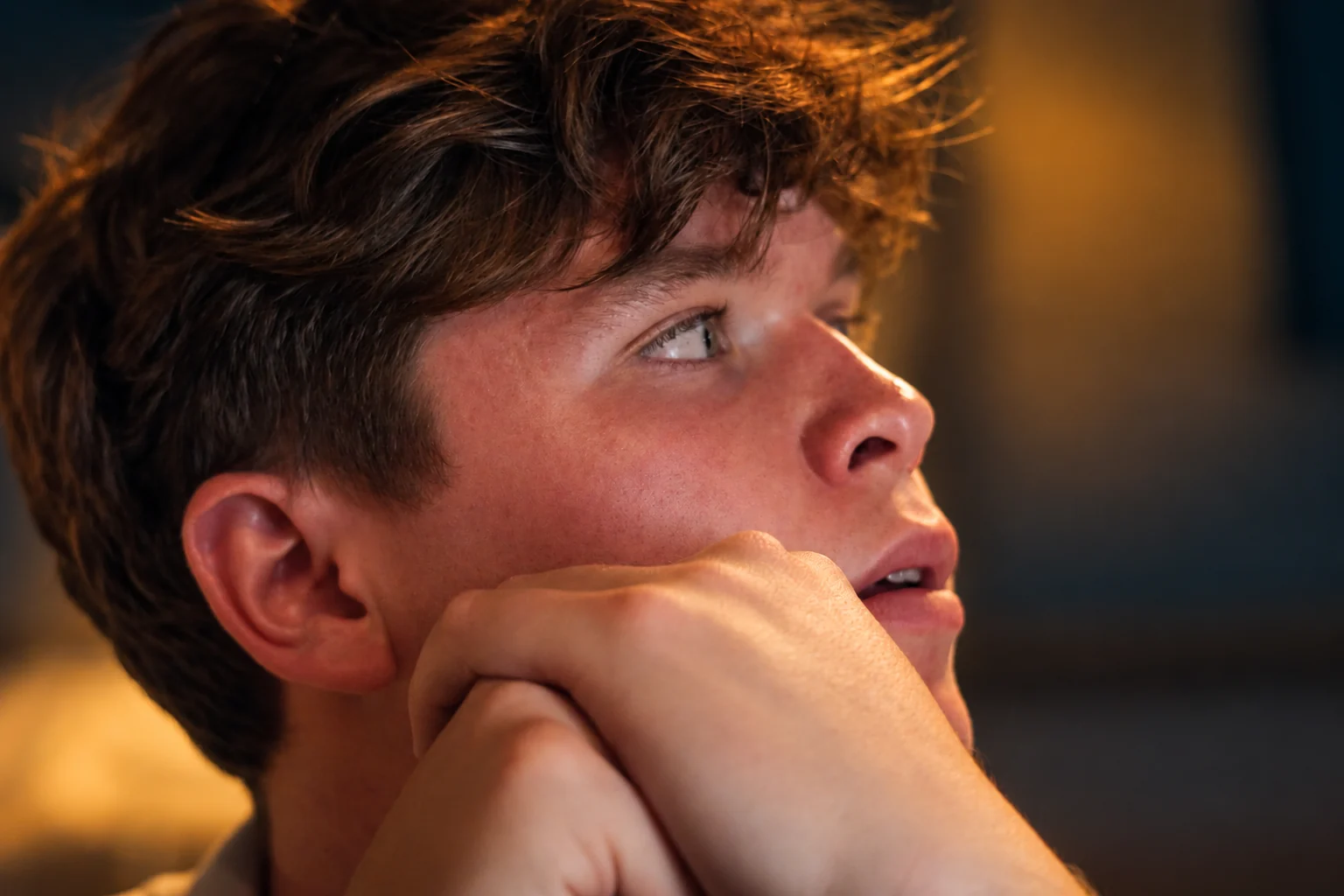Le regard et la main d’un homme dans une lumière chaude, série flo.