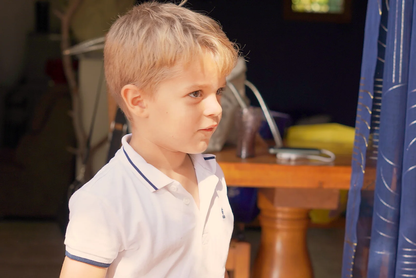 Portrait de profil d’un enfant en polo clair à la crémaillère de Leslie.