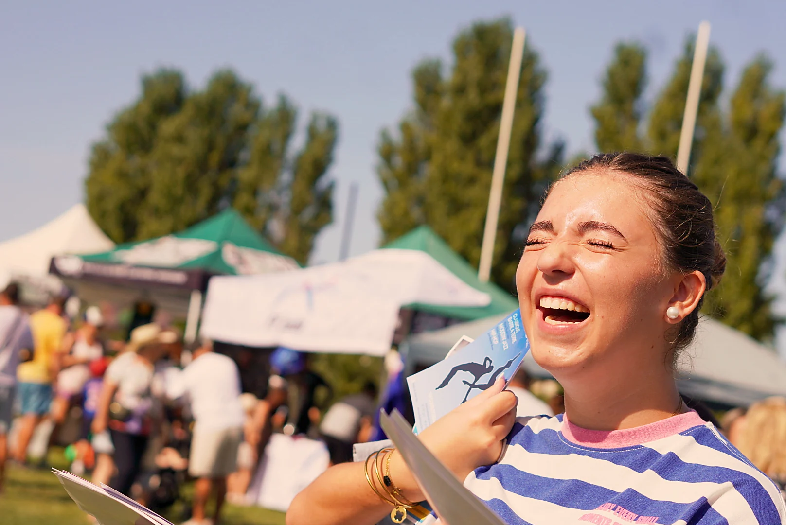 Une femme rit au soleil pendant le forum des associations.